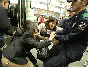 광고 조형물 아래쪽에서 시위를 벌이던 환경운동연합 활동가들을 경찰이 강제연행하고 있다. 